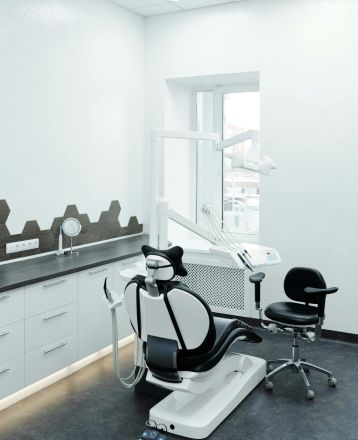 A bright, clean dental clinic showcasing a modern dental chair and equipment.